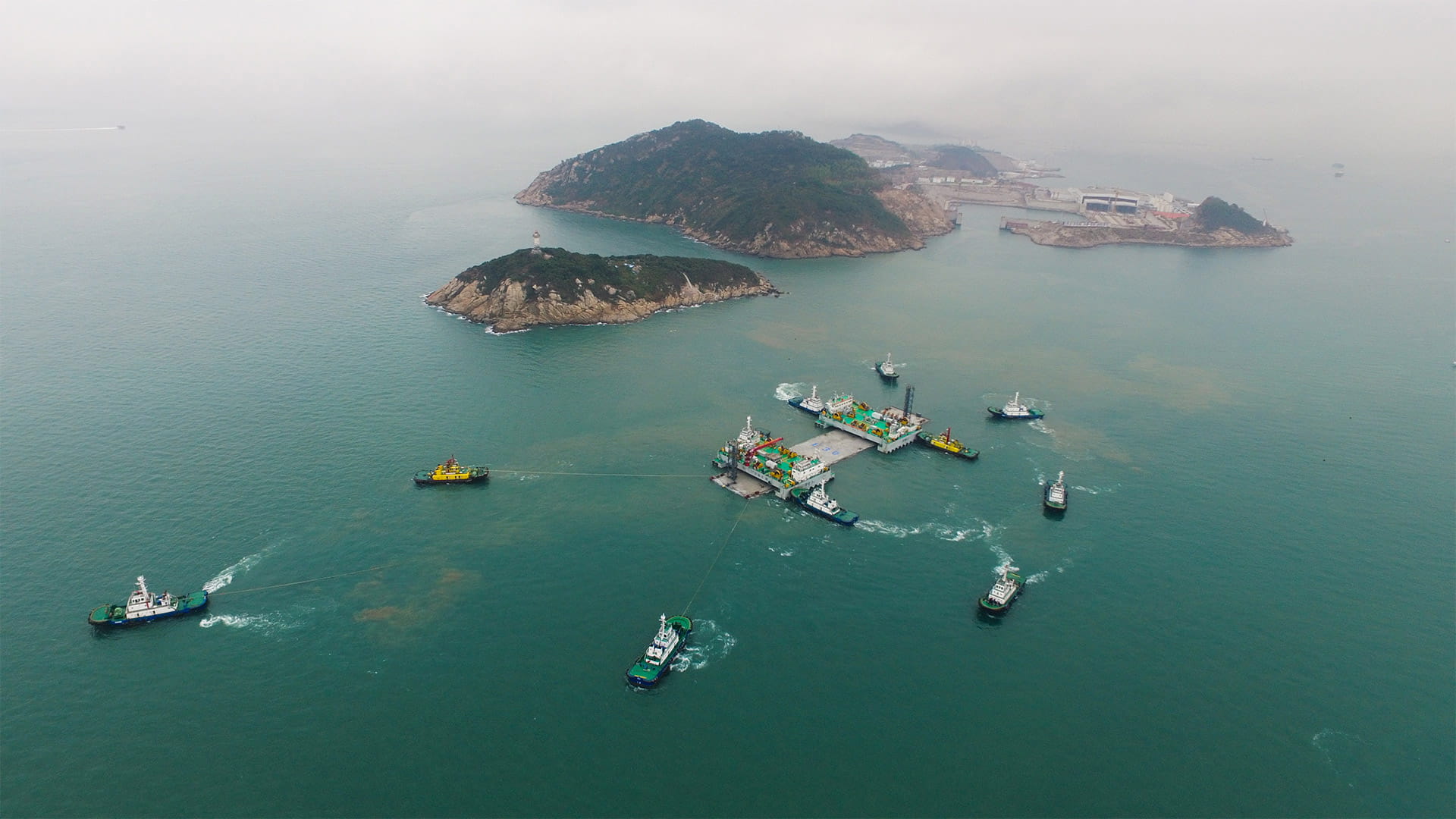 Bird's eye view of a construction site of an immersed tunnel surrounded by boats in a body of water